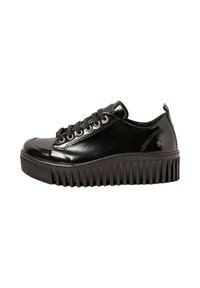 Zapatilla negra de cuero con un acabado brillante, punta redondeada, cordones planos y una suela gruesa y estriada. Presenta una sutil marca en el lateral.