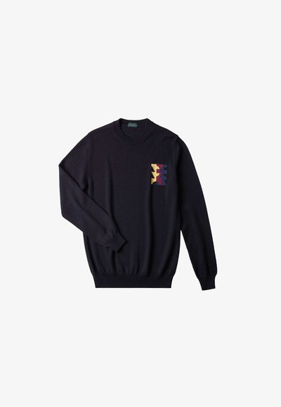 Navy Pullover mit langen Ärmeln und ripp abgeschlossenem Rundhalsausschnitt. Verfügt über ein farbenfrohes geometrisches Muster im linken Brustbereich. Glatte Textur.