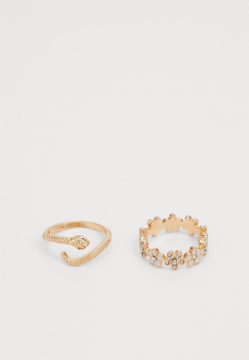 Goldfarbene Ringe: einer mit Schlangendesign und strukturiertem Band, der andere mit floralen Akzenten, klaren Steinen und gewellten Kanten.