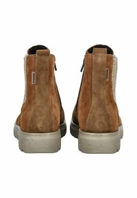 Botas de tobillo de ante marrón con una textura suave, que cuentan con un cierre de cremallera y una suela de un gris claro en contraste. La vista trasera destaca los detalles del material.