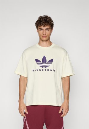 Ljusgul oversized t-shirt med lila "BASKETBALL"-text och logotyp, med rund hals och korta ärmar. Snygg bomullsmaterial.