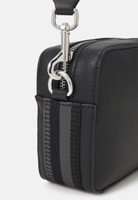 Borsa in pelle nera con texture, dotata di una cerniera argentata, un gancio argentato e un'accensione in tessuto a righe grigie e nere. Forma rettangolare compatta.