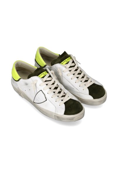 Sneakers bianchi in pelle con dettagli in suede verde e un tallone giallo brillante. Presentano una suola in gomma e lacci beige. Incluso un dettaglio del logo laterale.