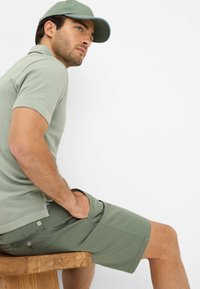 Lysegrøn polo skjorte og matchende shorts, lavet af blødt stof med en struktureret overflade. Har en afslappet pasform og sidelommer.