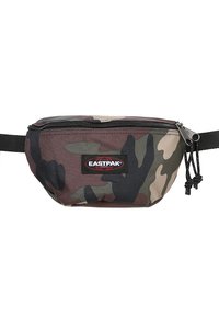 Riñonera de camuflaje hecha de un tejido duradero, con cierre de cremallera, correa ajustable y un parche rojo del logo de Eastpak en el frente.