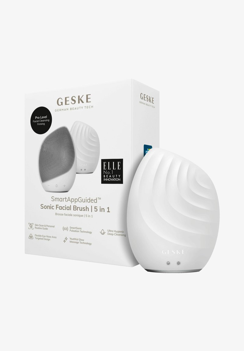 Sonic ansigtsbørste i hvid silikone med bølgemønster, ledsaget af en mærkeæske. Funktioner inkluderer knapper og et slankt, ergonomisk design.