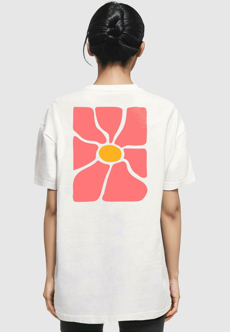 Weißes Baumwoll-T-Shirt mit einem großen pinken Blumenmotiv mit gelbem Zentrum auf dem Rücken, kurzen Ärmeln und lockerer Passform.