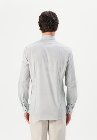 Men's long-sleeve shirt, light gray with a geometric print, buttoned cuffs, and a small collar. Smooth fabric with tailored fit.