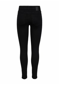 Jean skinny noir avec une texture lisse et deux poches arrière. Présente une étiquette en cuir sur la taille et un design ajusté.