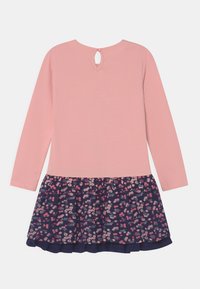 Vestido de manga larga con un top rosa y una falda de patrón floral en azul marino. Cierre de botón en forma de ojete en la parte posterior. Tejido suave con un diseño divertido.