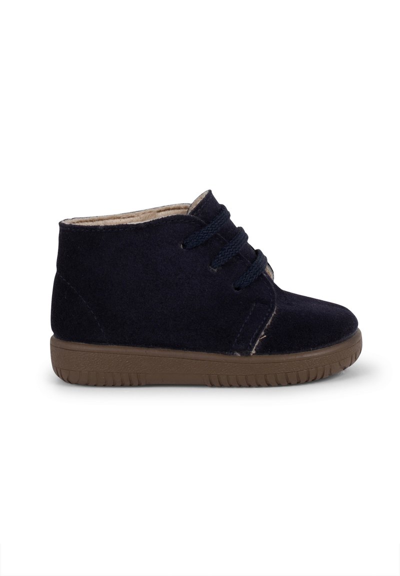 Stivaletti alla caviglia in suede blu navy con suola in gomma marrone, lacci anteriori, interno morbido e dettagli di cucitura minimali sui lati.