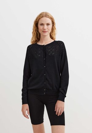 Black knitted cardigan with a textured eyelet pattern on the shoulders, button-up front, and ribbed cuffs and hem.