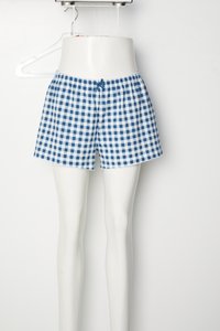 Blue and white checked shorts made of lightweight fabric with an elastic waistband and a small bow detail at the front. Scalloped hem.