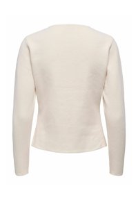 Haut à manches longues en beige clair avec un col rond. Tissu doux et texturé, design ajusté se resserrant à la taille, dos lisse.