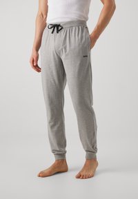 Pantalon de survêtement gris en mélange de coton, avec taille à cordon de serrage et poignets côtelés. Logo imprimé sur la cuisse gauche.