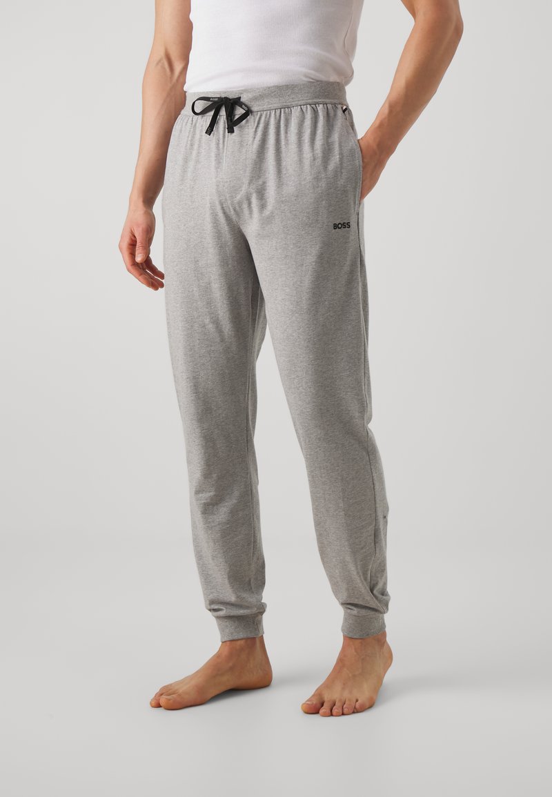 Pantalon de survêtement gris en mélange de coton, avec taille à cordon de serrage et poignets côtelés. Logo imprimé sur la cuisse gauche.