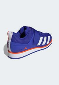 Fioletowy but sportowy z białymi paskami, z rzepem, przewiewna siateczkowa cholewka i pomarańczowe akcenty na podeszwie oraz logo.