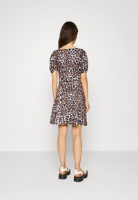 Vestido curto com padrão de leopardo, mangas bufantes, corpete ajustado e saia rodada. Apresenta um decote redondo e tecido suave.