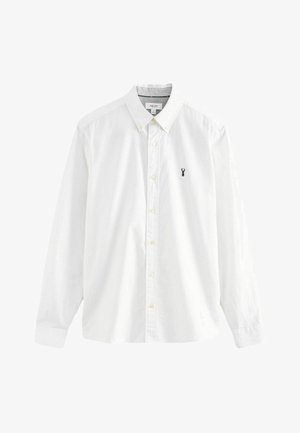 Camicia bianca a maniche lunghe in cotone. Presenta un colletto con bottoni, bottoni gialli e un piccolo logo di astice navy sul lato sinistro del petto.