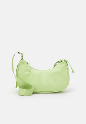 Bolso bandolera de nailon verde claro con forma redondeada, correa ajustable y detalles con cordones en los laterales. Textura suave, diseño minimalista.