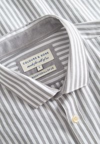 Camicia a righe in cotone grigio e bianco con colletto button-down, dotata di un'etichetta che riporta "COLOURS & SONS", taglia L.