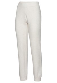 Light beige jogger pants made from soft, textured fabric, featuring a wide, elastic waistband and tapered ankle cuffs. No visible patterns.