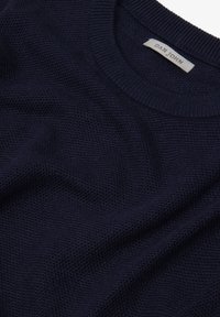 Suéter de punto azul marino con cuello redondo y un patrón texturizado. La etiqueta interior dice "DAN JOHN". Tela suave con un diseño casual.