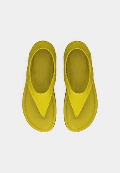 Φωτεινά κίτρινα δερμάτινα σανδάλια με φαρδιές λουρίδες σε σχήμα V και στρογγυλεμένη μύτη, τοποθετημένα δίπλα δίπλα σε λευκό φόντο.