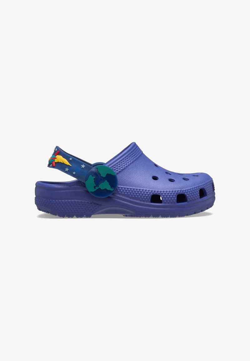Fioletowe klapki Crocs z otworami wentylacyjnymi, teksturowaną powierzchnią i odpinanym paskiem z wzorem globu i gwiazdy. Wykonane z lekkiego materiału.