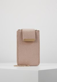 Różowa, błyszcząca torebka na ramię na telefon z klapką, złotymi okuciami i łańcuszkowym paskiem; prostokątny kształt z teksturowanym wykończeniem.