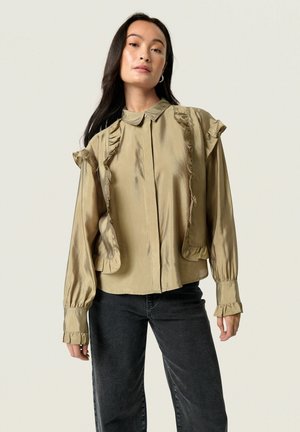 Khaki satin bluse med rynkede detaljer langs kraven og ærmerne, med knaplukning og indsamlede manchetter. Båret med mørke jeans.