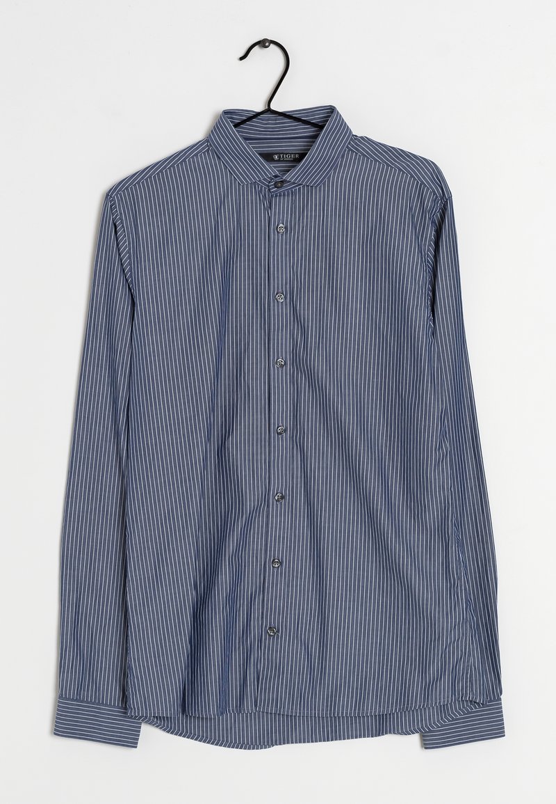 Camicia a maniche lunghe a righe blu e bianche con chiusura a bottoni, colletto classico e texture liscia, appesa a un gancio nero.
