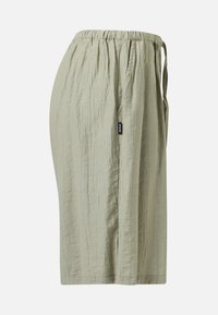 Jupe midi beige clair texturée avec une ceinture élastique froncée et une étiquette de marque noire sur le côté.