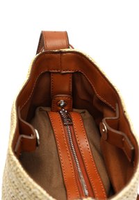 Vävd halmhandväska med bruna läderdetaljer. Har en ficka med dragkedja och ett rymligt innerutrymme med mörkt tygfoder.