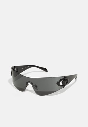 Melni pārmērīgi lieli saulesbrilles ar elegantu dizainu, izliektiem stikliem un lauvas galvas akcentiem sānos. Gluda tekstūra un minimālisma stils.