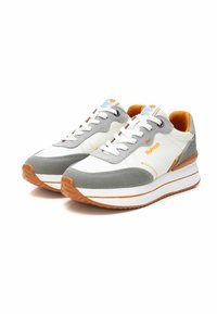 Sneakers grigi e bianchi con dettagli arancioni, dotati di una tomaia testurizzata, lacci piatti e una suola spessa bianca con una striscia arancione.