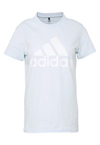 Camiseta de algodón color azul claro con mangas cortas, cuello redondo, que presenta un gran logo blanco de Adidas en el frente. Textura suave, diseño casual.