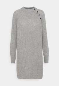Abito in maglia grigia con texture a coste, scollatura rotonda e bottoni decorativi su una spalla. Le aperture laterali migliorano i movimenti.