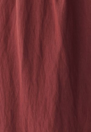 Tkanina v rustikálnej farbe s textúrovaným, vrásčitým povrchom. Materiál sa zdá byť mäkký a ľahký, vhodný na závesy alebo vrstvenie.