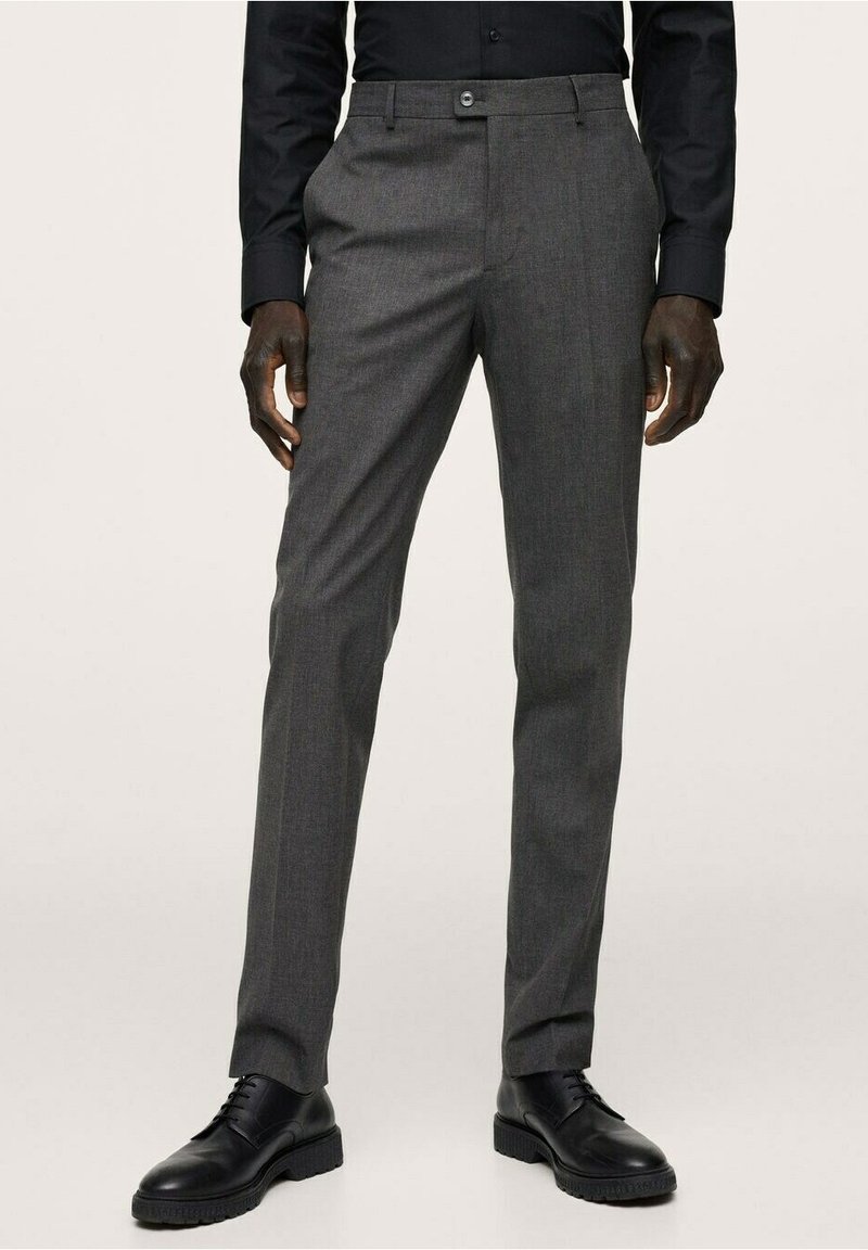 Graue maßgeschneiderte Hosen aus strukturiertem Stoff, mit flacher Vorderseite, Gürtelschlaufen und Knopfverschluss, kombiniert mit schwarzen Schnürschuhen.
