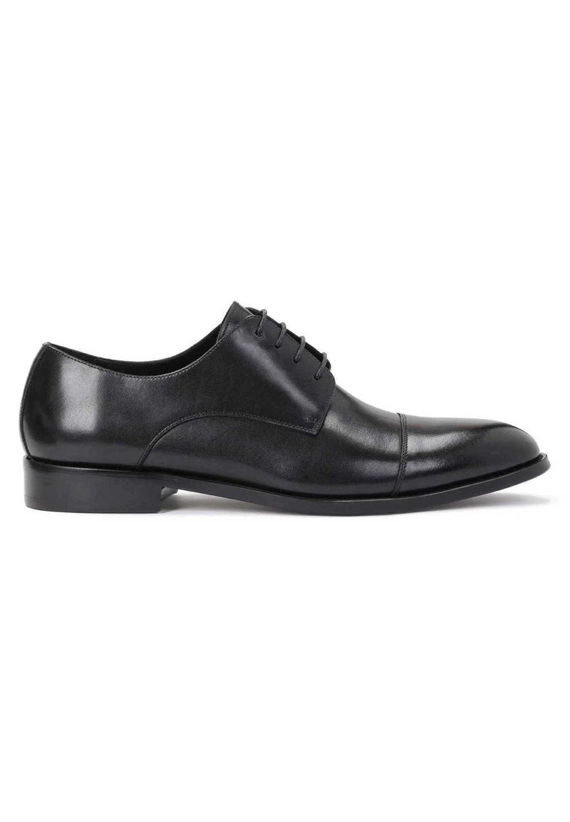 Schwarze Lederschuhe mit glatter Oberfläche, spitz zulaufender Zehenpartie, Schnüroptik und dezenten Nähten entlang des Schafts und der Zehenkappe.