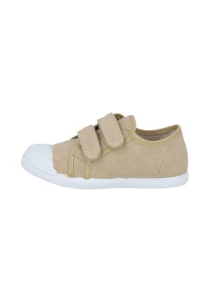 Zapatilla infantil de lona beige con puntera y suela de goma blanca, con dos correas de velcro para cierre.