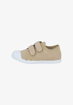 Zapatilla infantil de lona beige con puntera y suela de goma blanca, con dos correas de velcro para cierre.