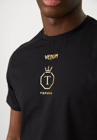 Venum UNMATCHED TOPURIA EDITION - Majica kratkih rukava s printom - black/antique gold