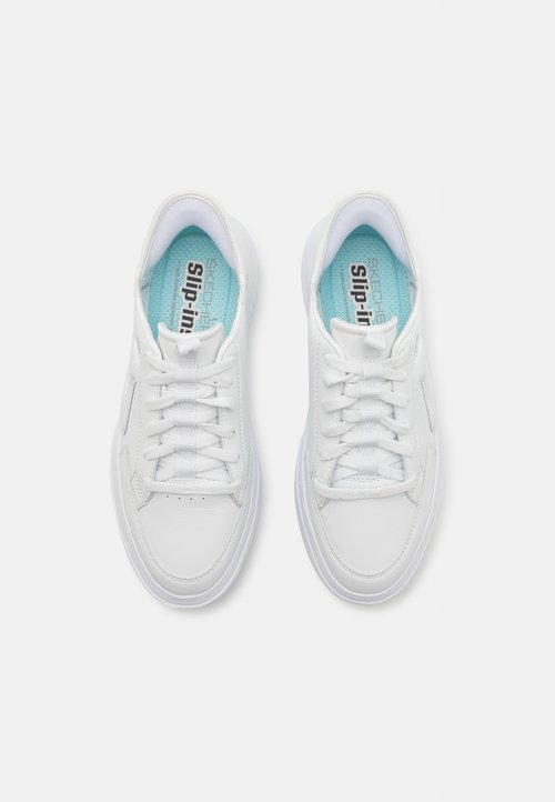 White sneakers with a smooth leather upper, matching eyelets, and a light blue insole featuring the text "SKECHERS slip-in."