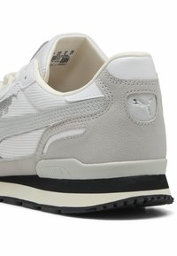 White and gray sneaker with textured mesh and smooth leather panels, featuring a black outsole and Puma logo on the heel.