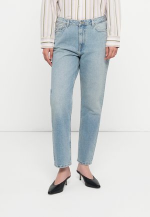 Light blue denim jeans with a straight leg fit, featuring front pockets, a button closure, and subtle fading, paired with black high-heeled shoes.