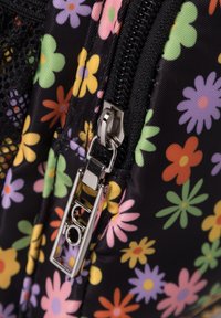 Zwarte stoffen tas met een kleurrijk bloemenpatroon van oranje, roze, gele en groene bloemen; inclusief een zilveren ritsluiting.