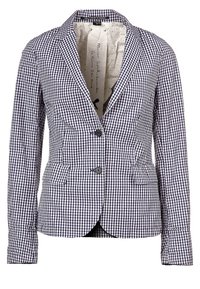 Blazer a righe blu navy e bianche con design aderente, due tasche frontali, due bottoni e una fodera a pois. Tessuto in cotone lavorato su misura.