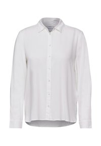 Chemise blanche à manches longues avec un col classique, texture lisse et ourlet arrondi. L'avant a une fermeture à boutons avec des boutons répartis de manière uniforme.